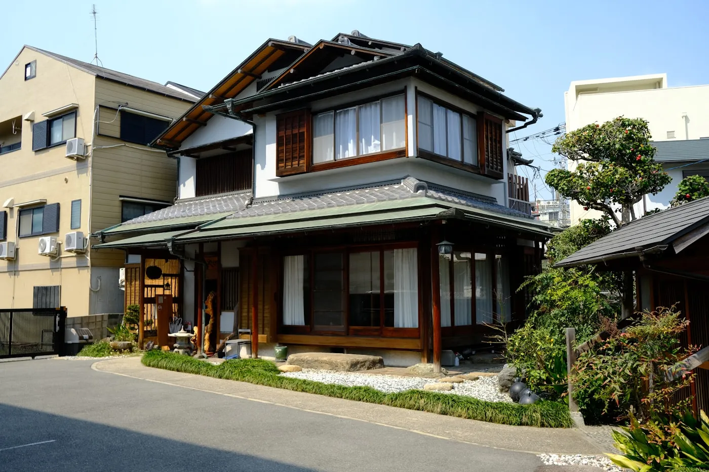 瓦屋根と木製の格子窓がある二階建ての日本家屋の外観