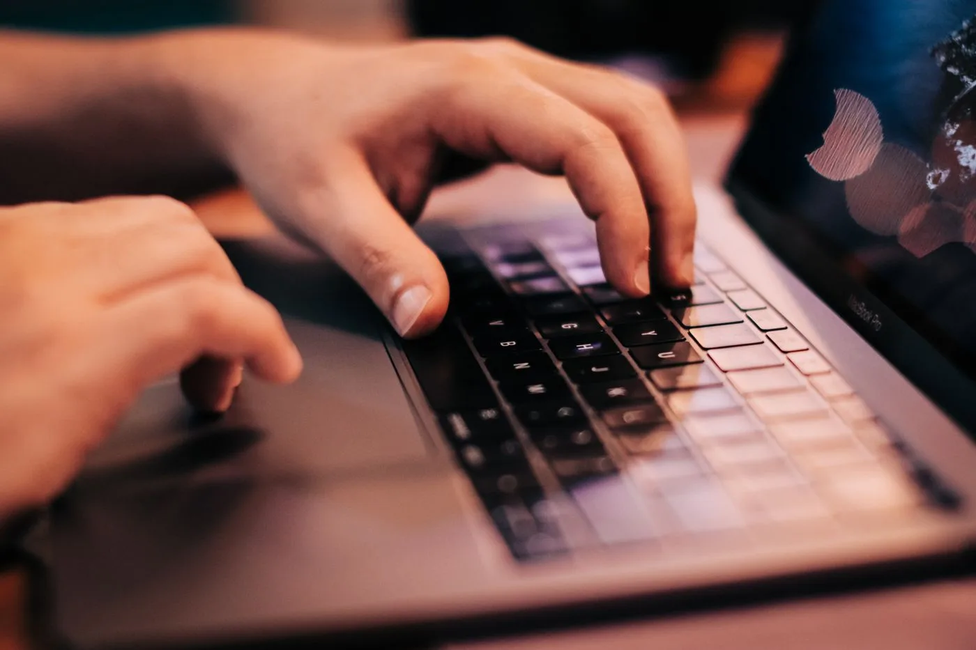 ノートパソコンのキーボードに両手を置いて入力している手元