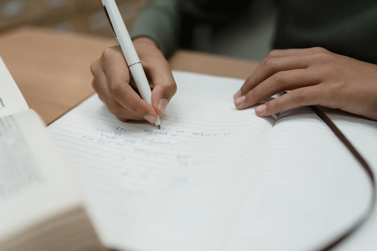 ノートに書き込んでいる手元と、開いたページ
