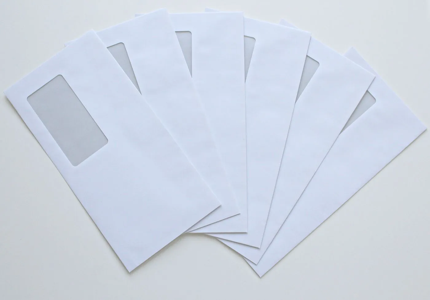 窓付きの白い封筒が6通、扇のように広げて置かれている