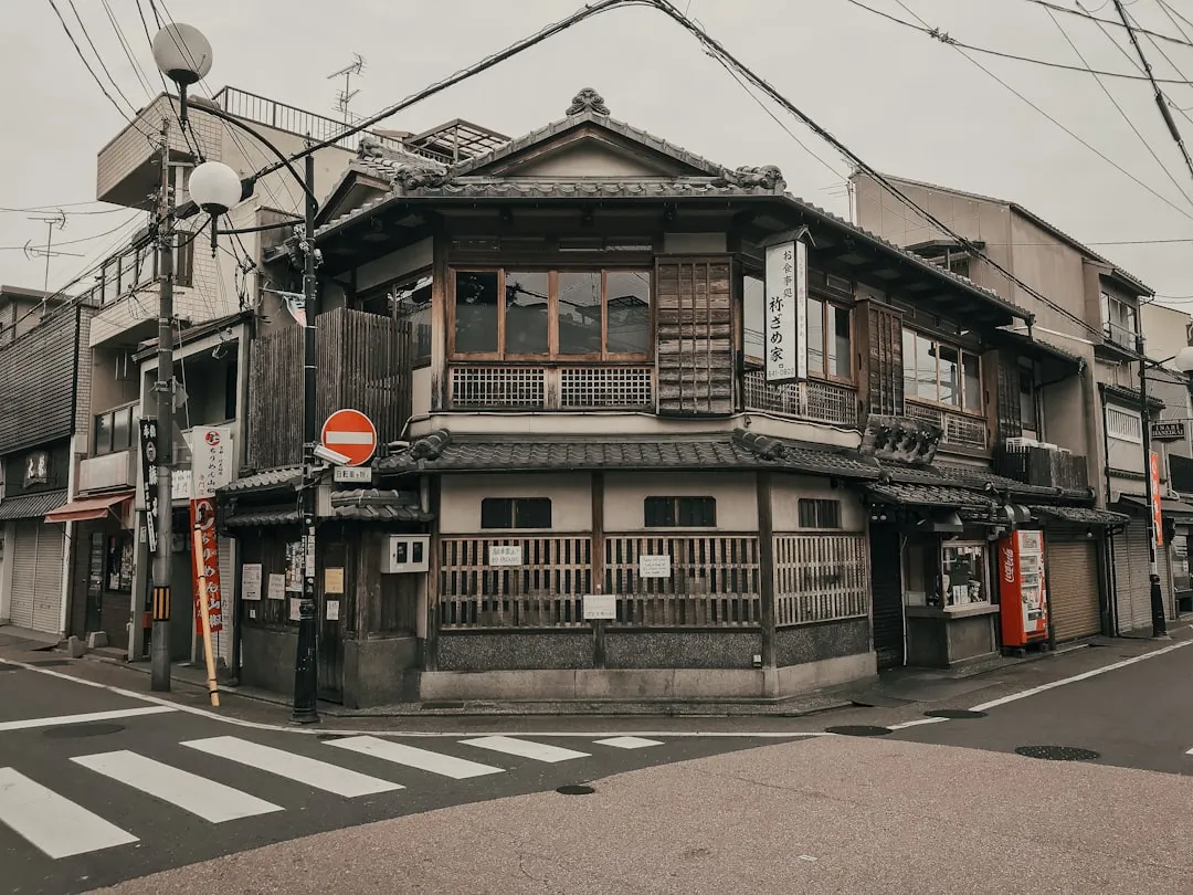 シャッターの下りた古い木造二階建ての建物が、人通りのない街角に建っている