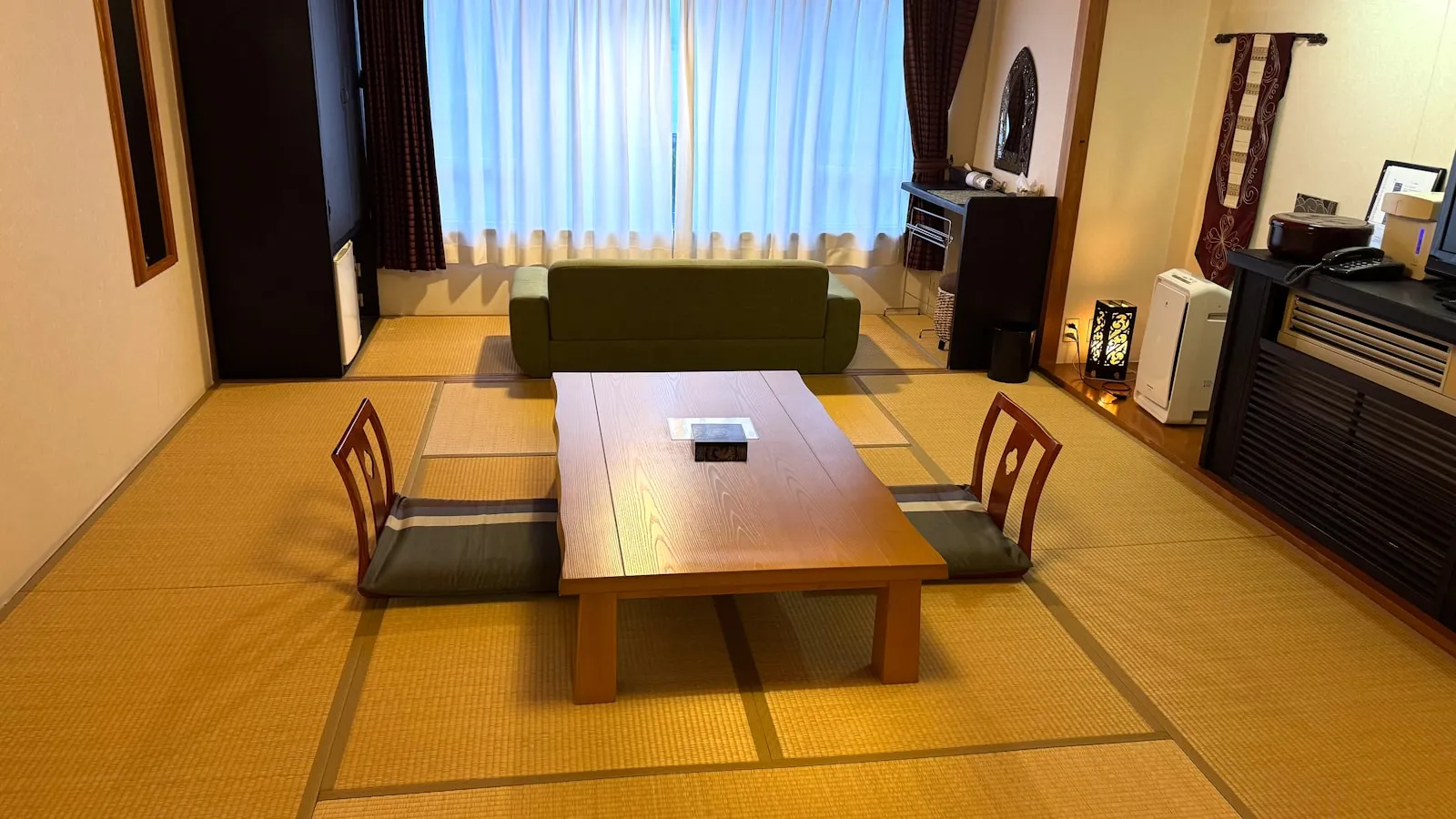 畳敷きの和室に低い座卓と座椅子が置かれた室内