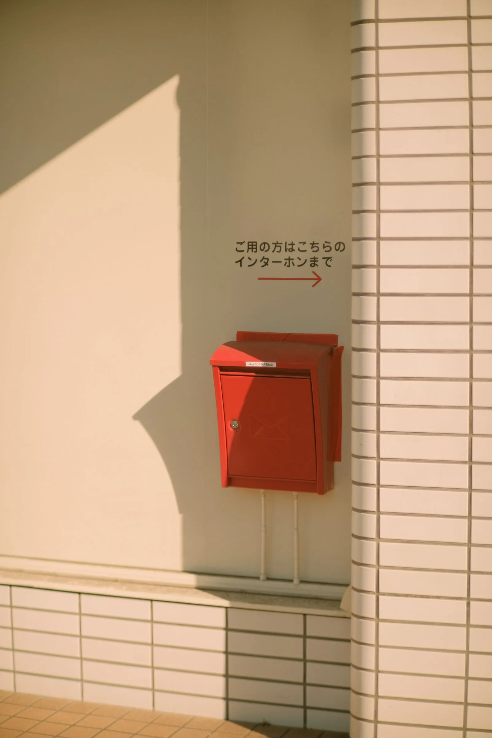 集合住宅の壁に取り付けられた赤い金属製の郵便受け