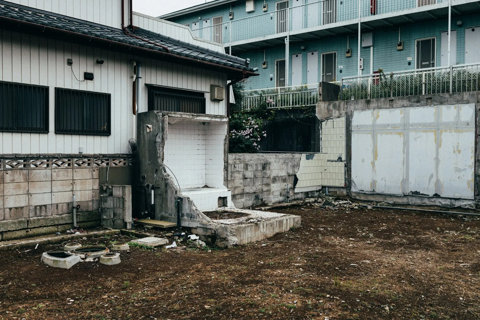 建物が取り壊されたあとの基礎とタイル壁が残る敷地
